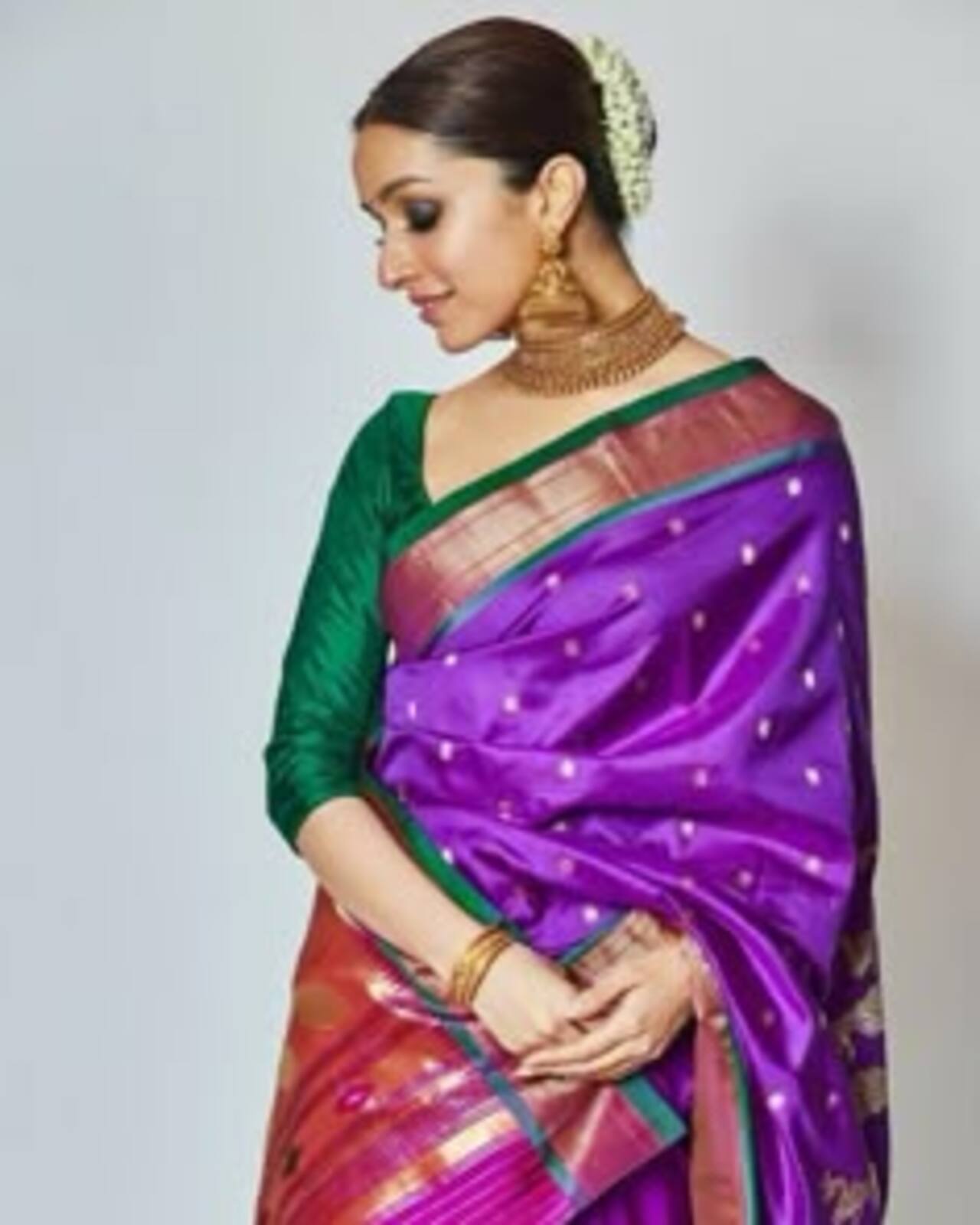 Shraddha brings out the Marathi mulgi in her with this vibrant purple Paithani saree with a contrasting green blouse. She accessorised with heavy gold temple jewellery and a classic hair bun adorned with flowers. 